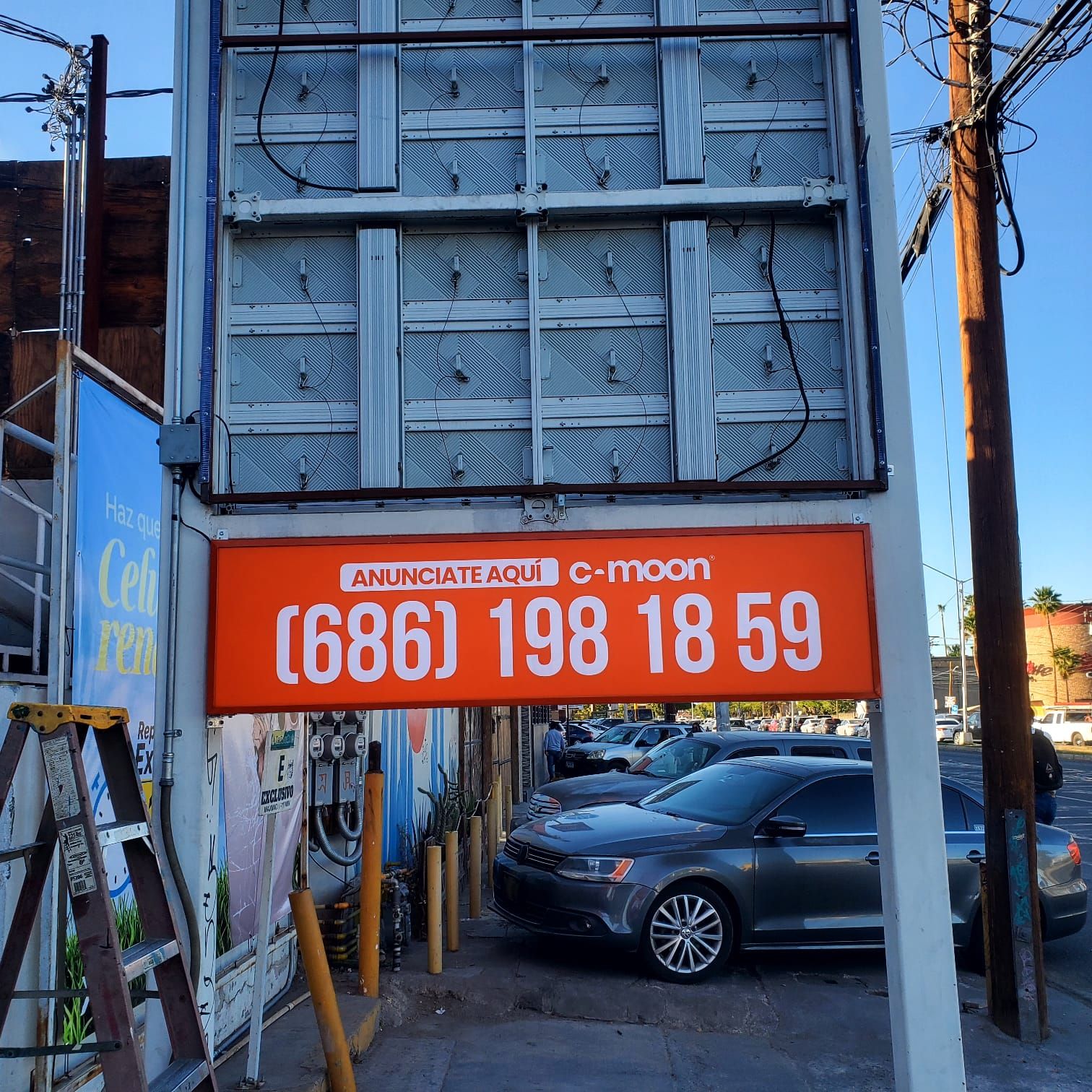 Estructura trasera de una pantalla LED con sus módulos y cableado, sobre una charola luminosa naranja de contratación de espacio.
