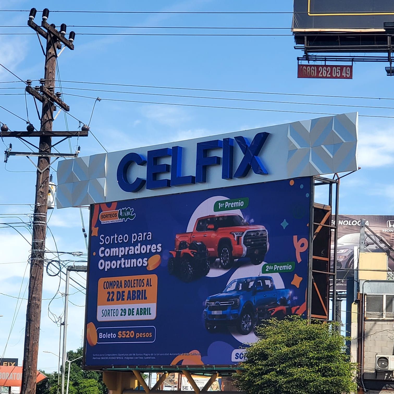 Espectacular de Celfix: letras de canal azules coronando un marco de panel de aluminio facetado sobre la lona publicitaria.